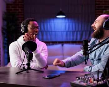 African American Host Engaging Entertaining Discussion With Celebrity During Live Stream Professional Studio Making Him Laugh Presenter Using High Quality Equipment Produce Comedy Podcast